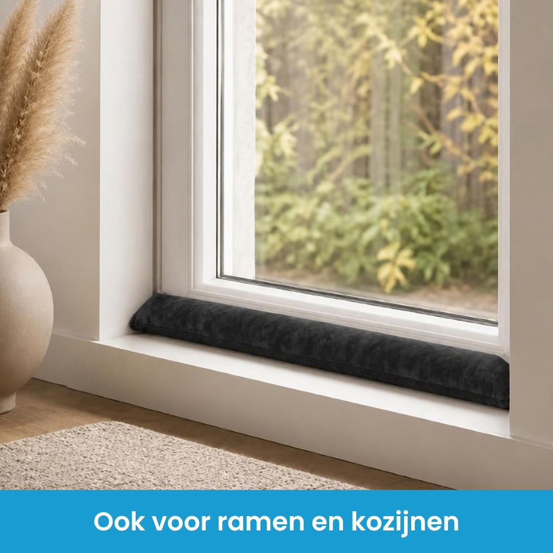 Tochtstopper zwart in het raamkozijn op de vensterbank, tegen tocht bij ramen